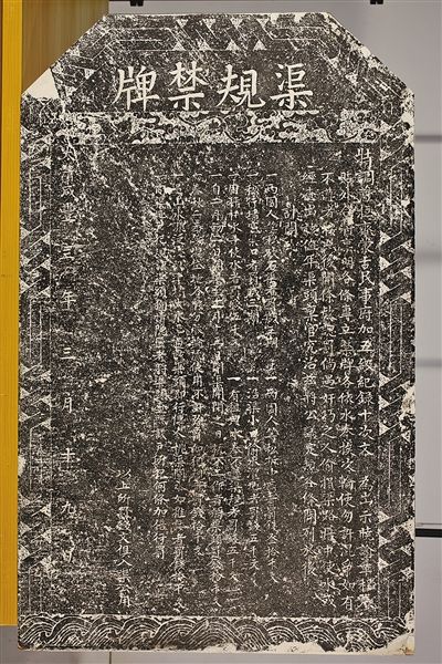 渠规禁牌石碑全貌。灰色花岗岩，碑额"渠规禁牌"四字篆书居中，下面是楷书刻写的水渠管理规定和处罚条文。