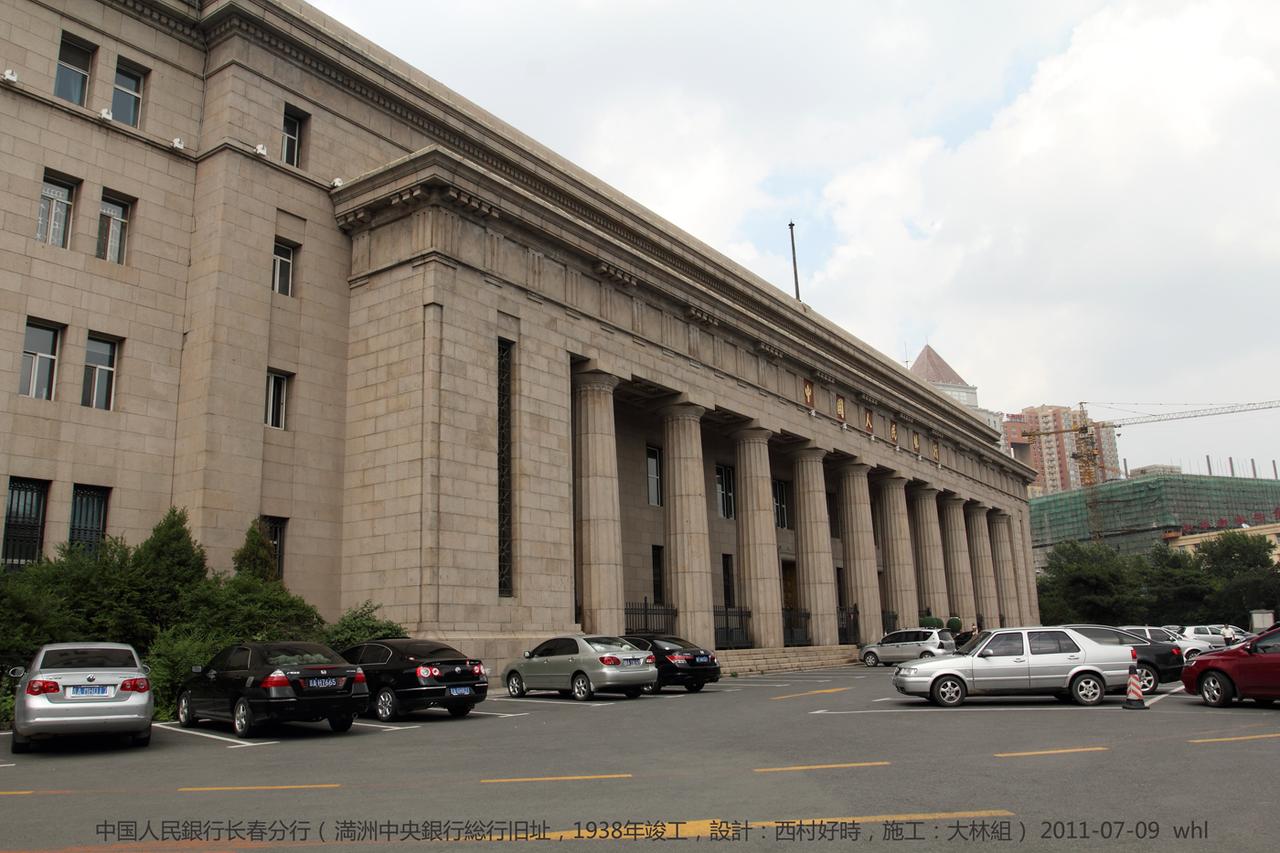 伪满中央银行旧址正立面,十根多立克石柱支撑的门廊上方悬挂中国人民银行标志