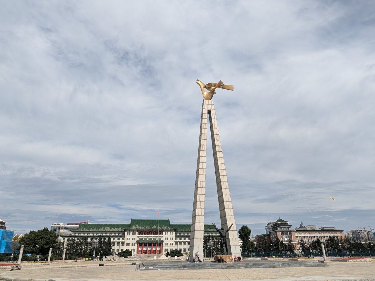 文化广场中央的太阳鸟雕塑和北面的地质宫，展示了广场中轴线与宫殿式建筑的对应关系
