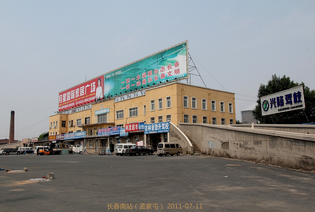 长春南站的站房和货运编组场，铁轨从站场延伸向一汽厂区方向