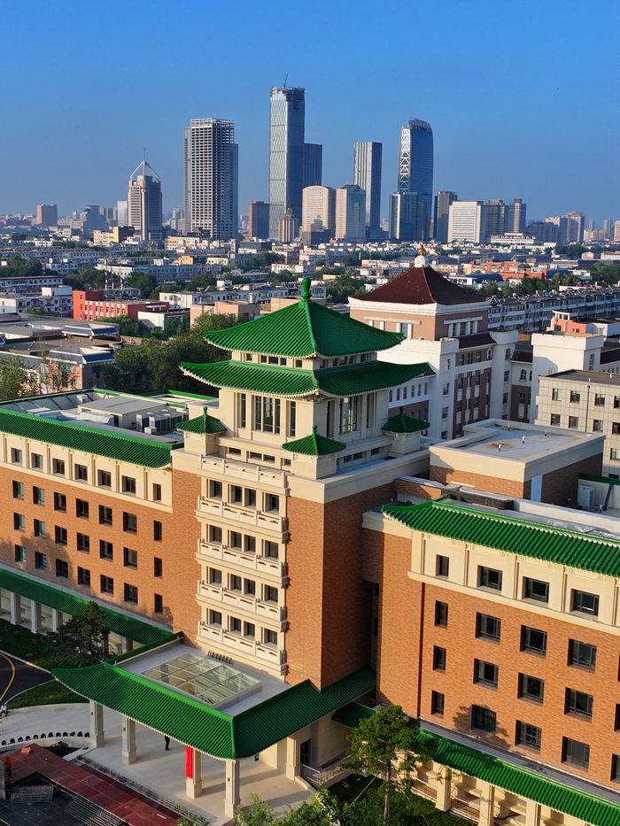 长春历史文化博物馆远景，黄墙绿瓦与青松搭配，融入新民大街历史建筑群