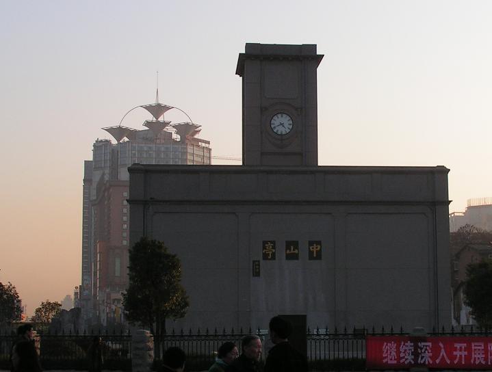 中山亭钟楼正面：灰色五层西式方形建筑，四面钟盘清晰可见