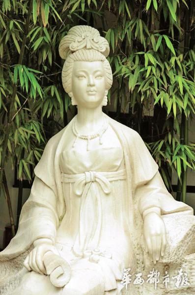 A white stone sculpture of Xue Tao dressed in traditional at