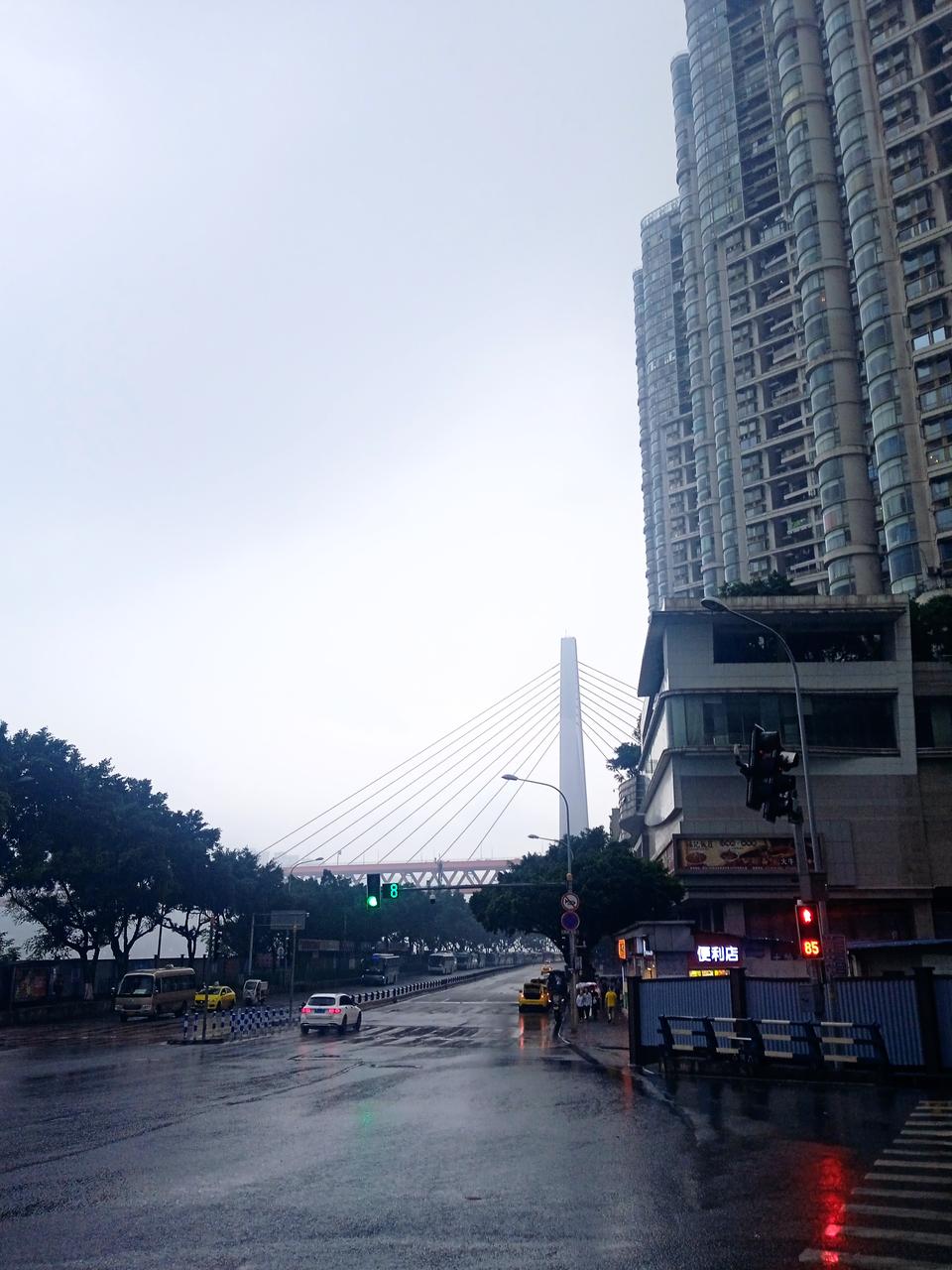 重庆的长滨路街景，可见路面紧贴江岸，一侧是城市建筑，一侧是江面