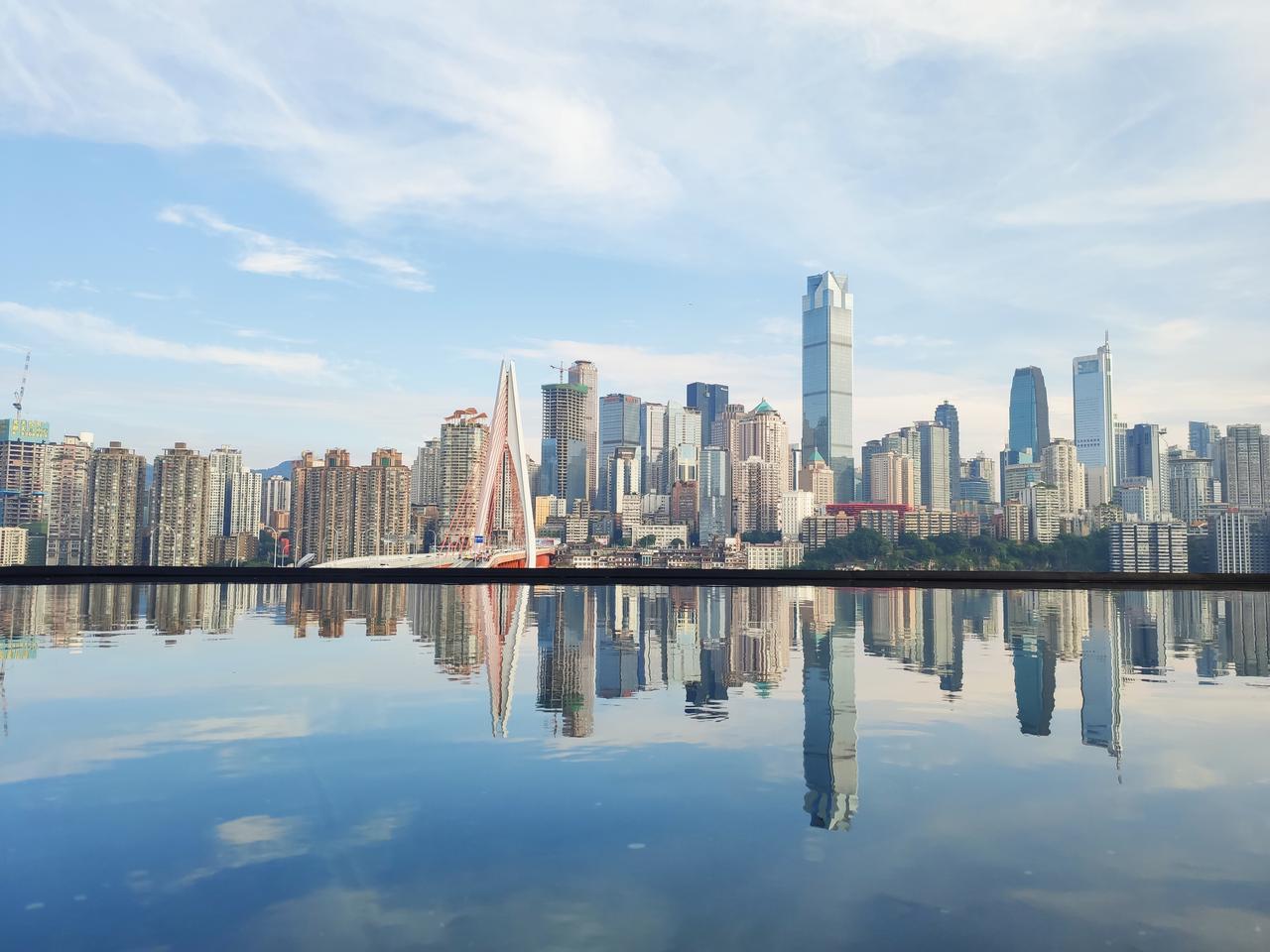 从空中俯瞰渝中半岛，长江和嘉陵江夹出狭长的半岛地形，滨江路沿两侧崖脚延伸