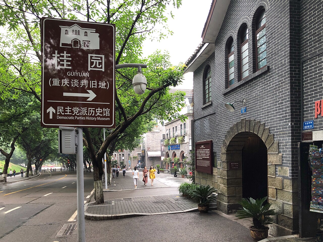 桂园入口处的灰色砖墙和铁门，左侧可见文物保护单位标识牌