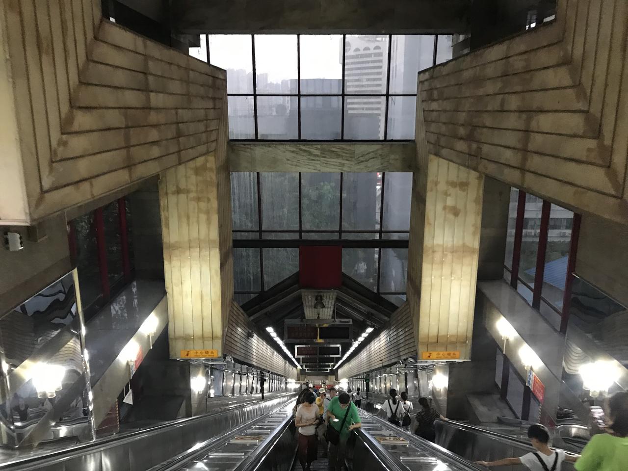 扶梯内部全透明玻璃顶棚，可以看到外部城市建筑