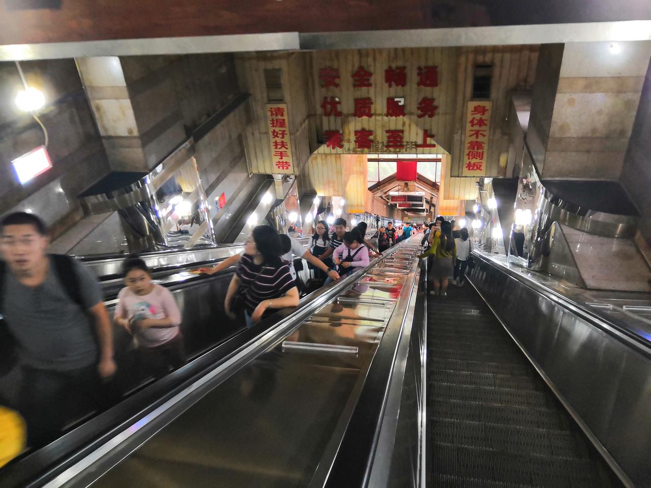 从扶梯入口向下看，30度倾斜的扶梯以透视消失在远处