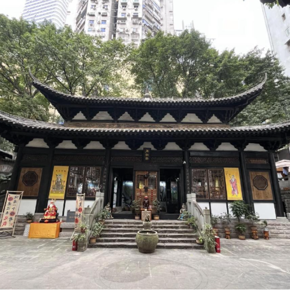 东华观藏经楼外景，匾额上书"藏经楼"三字，建筑位于居民楼之间的院落里，被现代城市包围