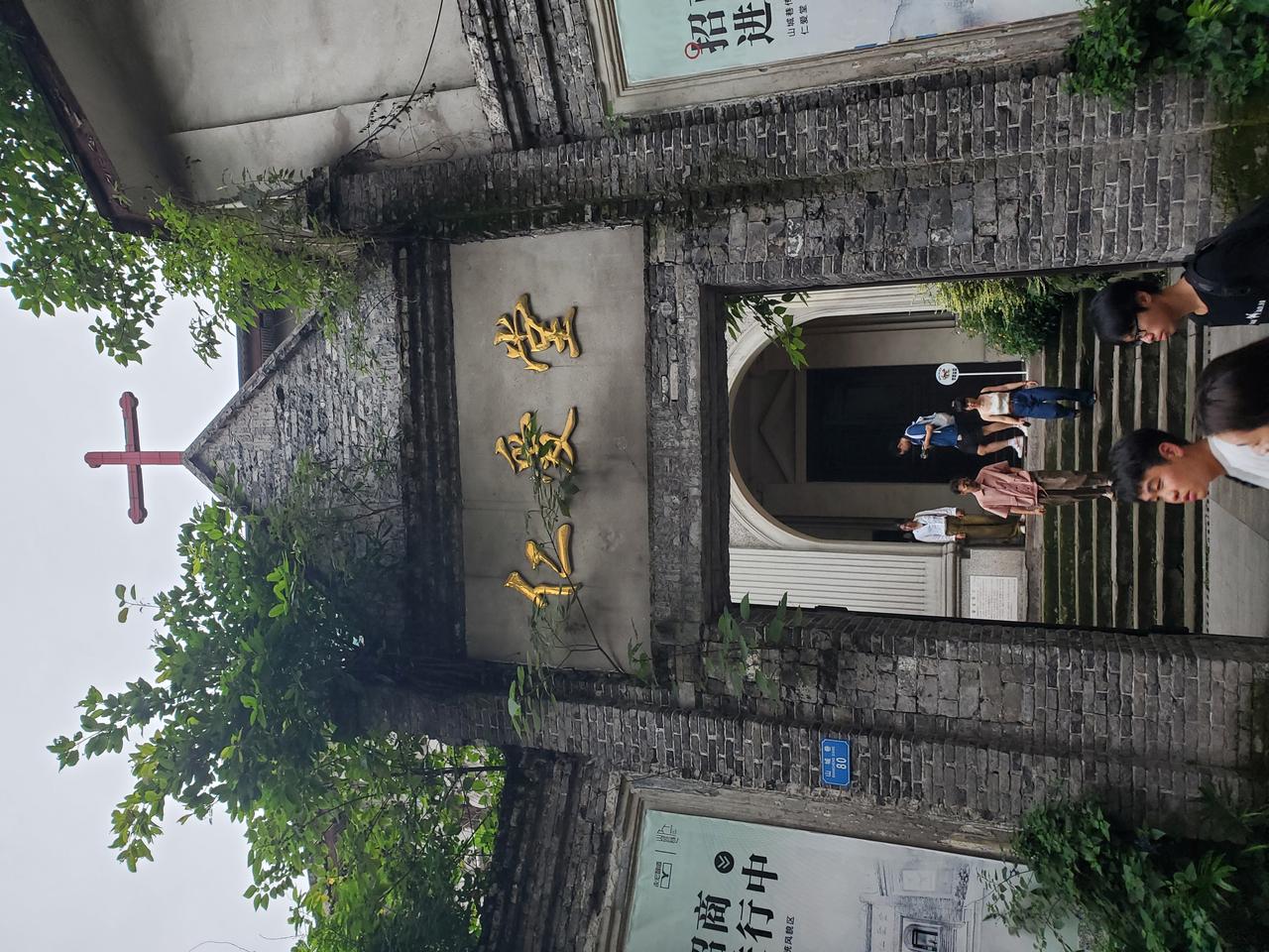 仁爱堂入口门楼，砖拱门上方的"仁爱堂"牌匾和十字架清晰可见