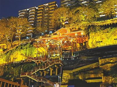 戴家巷崖壁步道夜景，步道灯光与嘉陵江对岸的城市灯光交相辉映