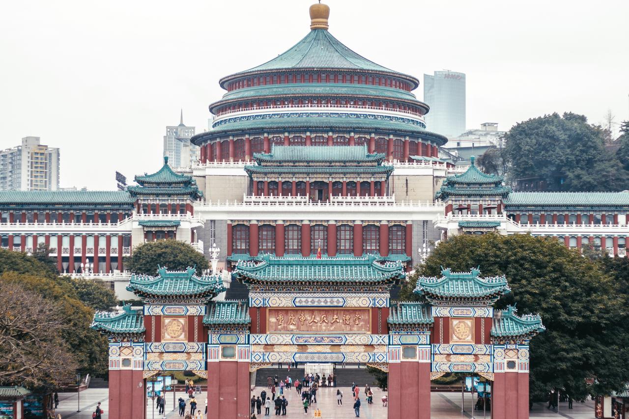 从人民广场看人民大礼堂正面,蓝色琉璃瓦穹顶在重庆阴天背景下极为显眼