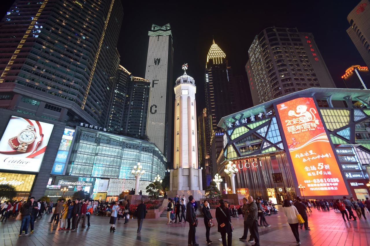解放碑纪念碑夜景，周围高楼密集，商圈灯光璀璨