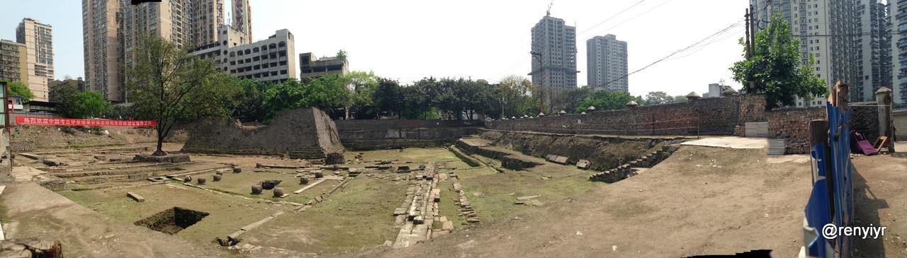 解放东路巴县衙门片区的老鼓楼遗址全景，夯土包砖高台基址被现代建筑环绕