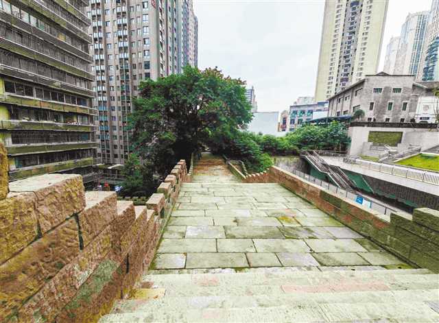 城墙另一角度，可见修复后的墙体顶部的雉堞和步道，城墙与崖壁紧密贴合
