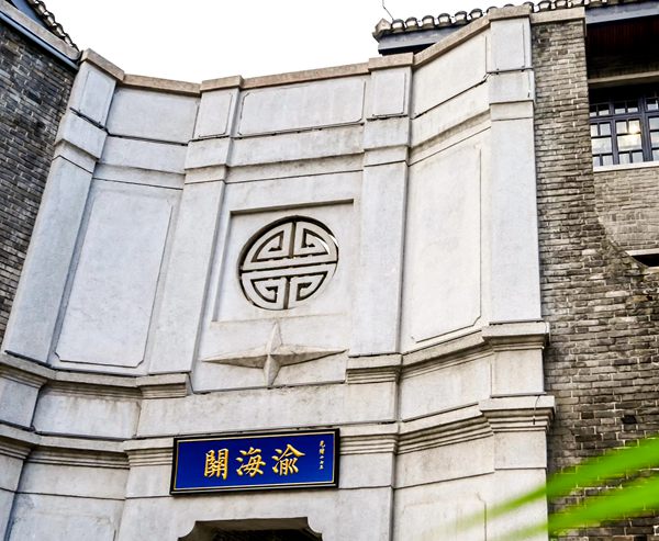 渝海关建筑群正门，青砖砌筑的四栋小楼组合院落，正门上挂着黑底金字招牌