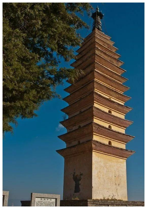 A tall, multi-tiered pagoda with wooden eaves extending outward, partially obscured by tree branches