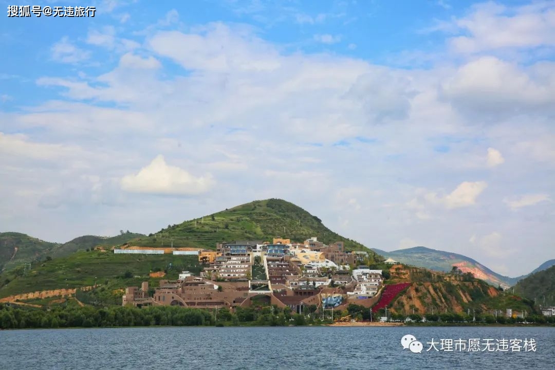 白色和咖啡色的建筑群从海东山坡层层叠落，背景是洱海和苍山