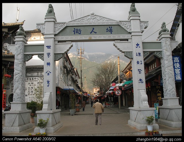洋人街白天的街景，行人稀少但店铺招牌醒目
