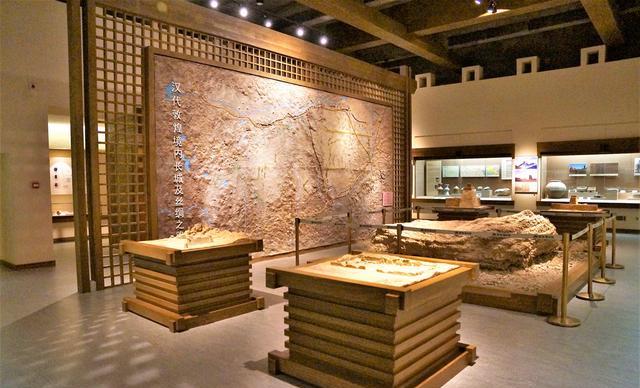 敦煌博物馆展厅内景：壁画残片与文物在展柜中陈列