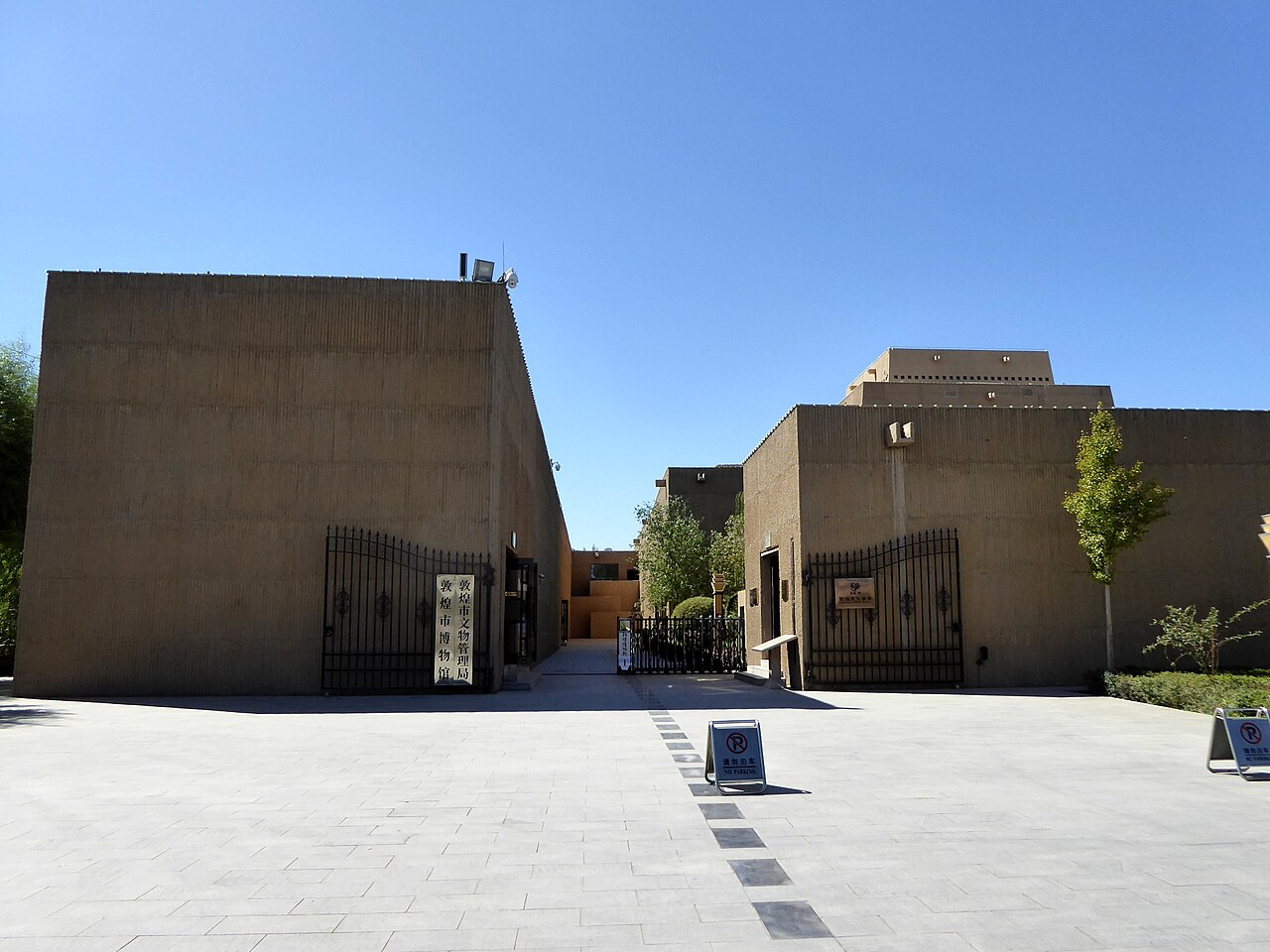 敦煌博物馆建筑外观，赭黄色墙面模拟石窟崖壁纹理