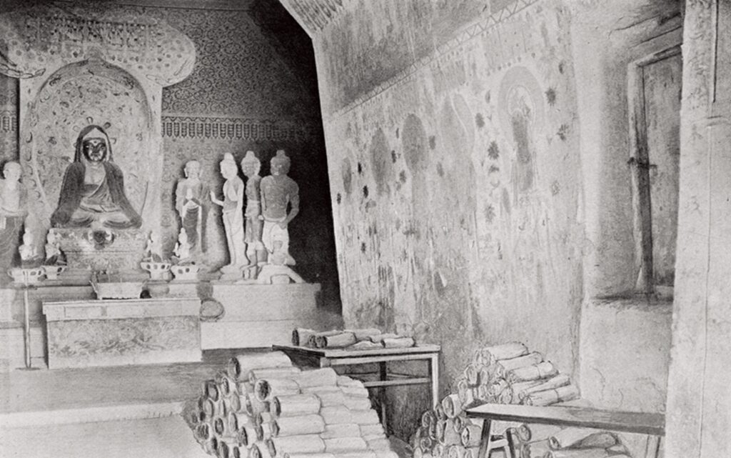 斯坦因1907年拍摄的藏经洞内景，可见成捆的写本堆叠在地上
