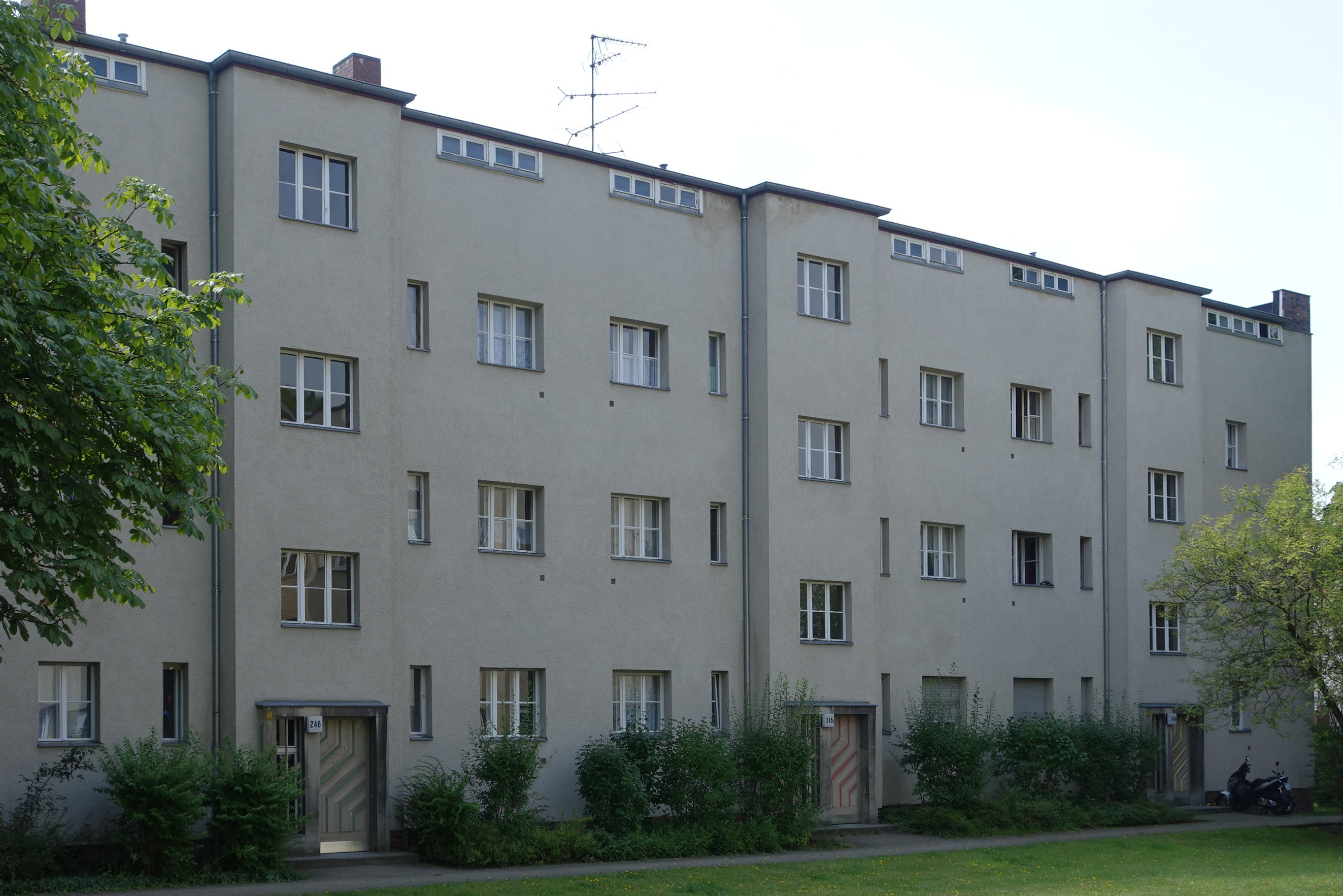 Buschkrugallee 的 Zeilenbau 线性建筑，红砖与浅色立面的标准 Taut 风格