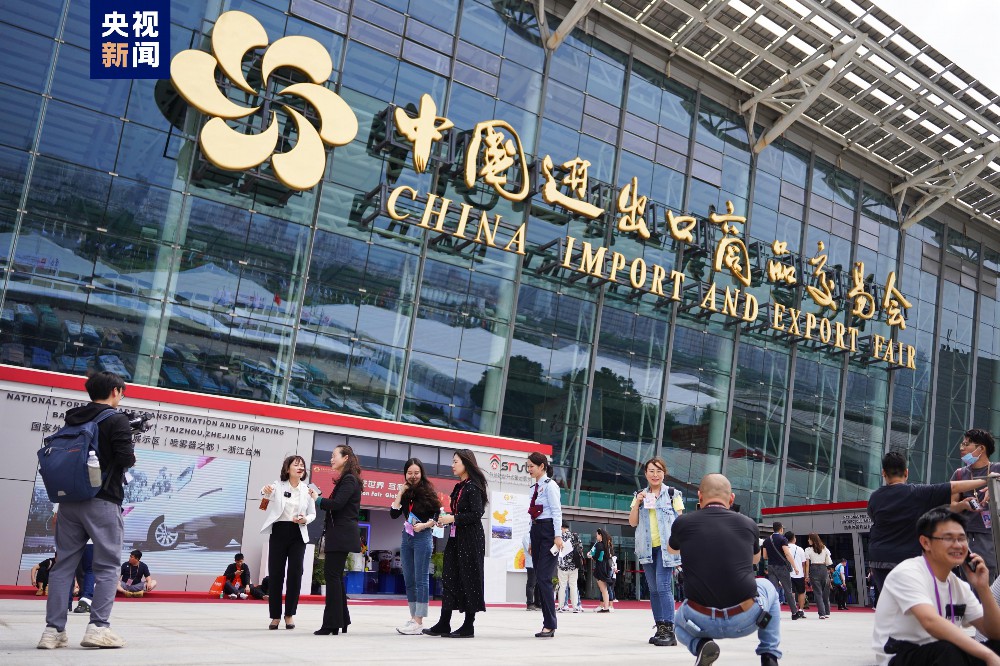People gather outside the China Import and Export Fair (Canton Fair) at Pazhou Trade Center, with some engaging in conve