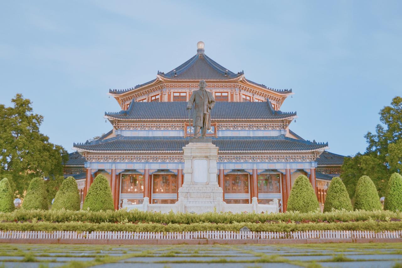 广州中山纪念堂正面全景，蓝色琉璃瓦八角攒尖顶、金色圆顶、"天下为公"匾额清晰可见