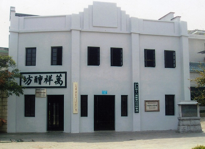 八路军桂林办事处旧址外景，银灰色两层砖木楼，门楣上书"万祥醩坊"