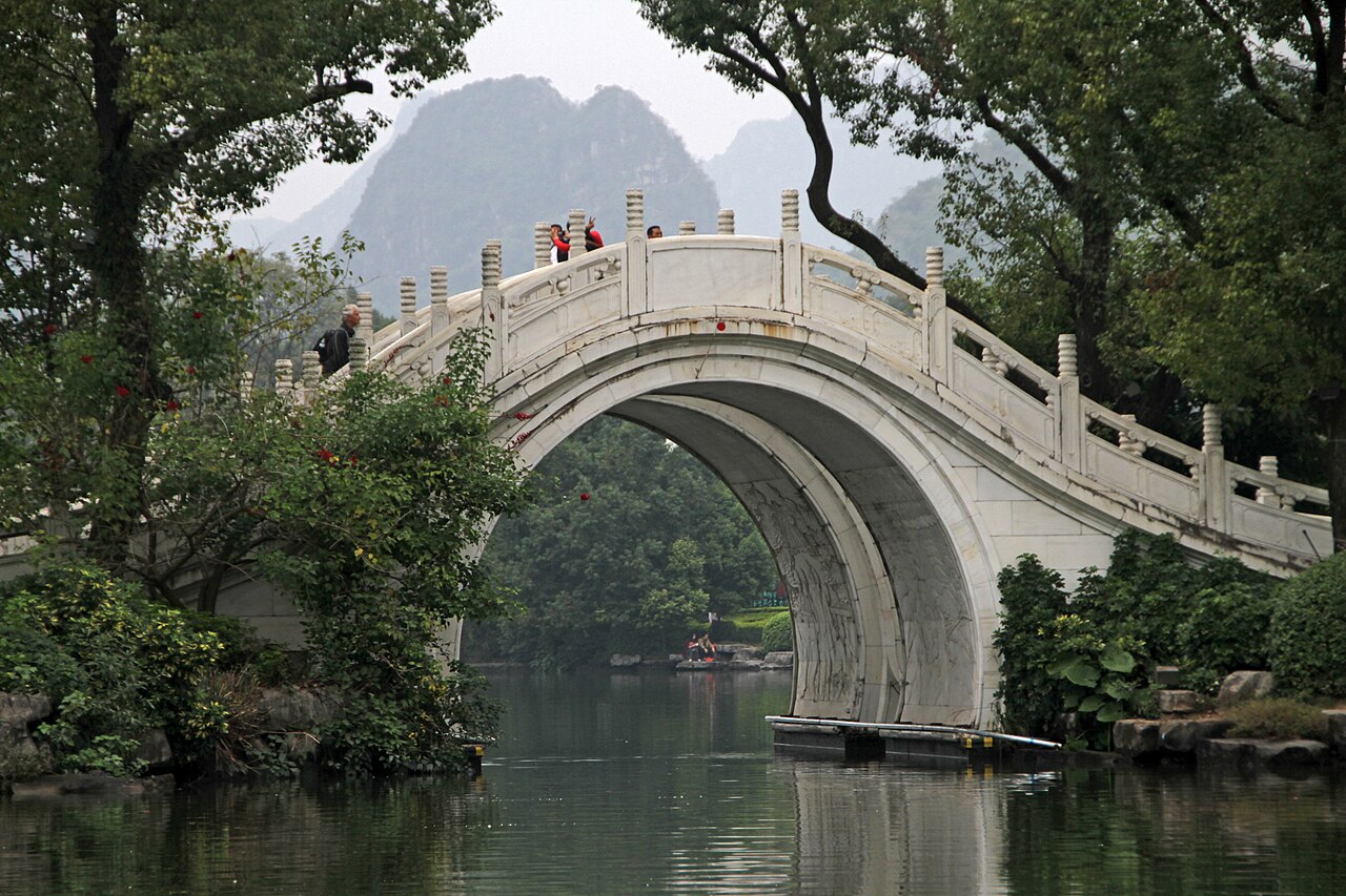 两江四湖桥栏上的壮锦几何纹样装饰，菱形回纹和铜鼓纹路清晰可见