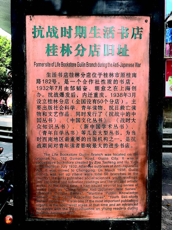 生活书店纪念碑旁的粉色简介信息牌，详细记载书店创办和经营史