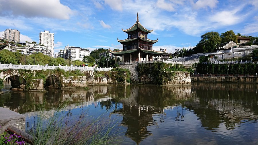 南明河滨河步道与河岸景色，远处是贵阳城市建筑