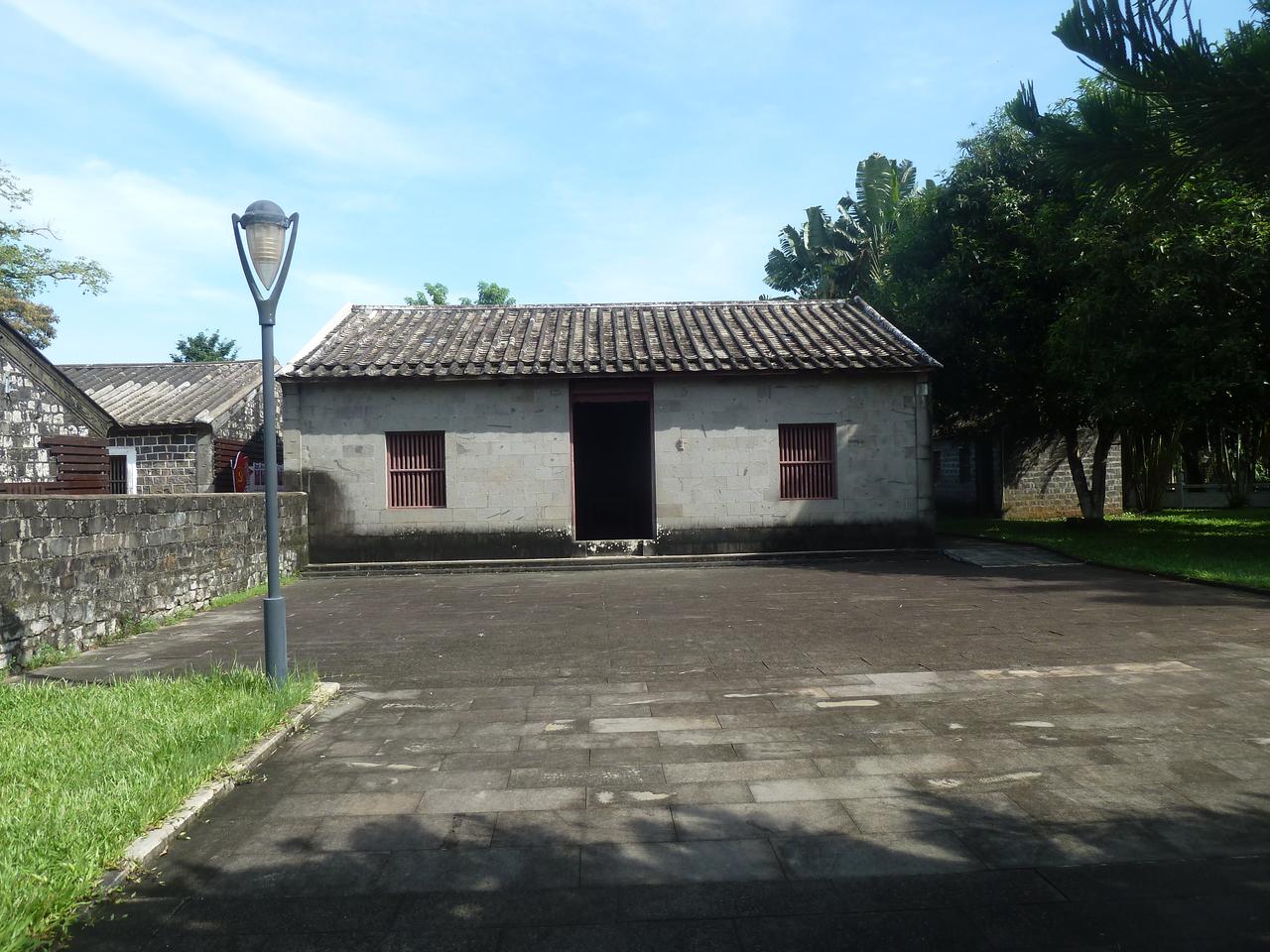 冯白驹故居正屋正面：灰色石墙、青瓦屋顶、红色木门与徐向前题写的横匾