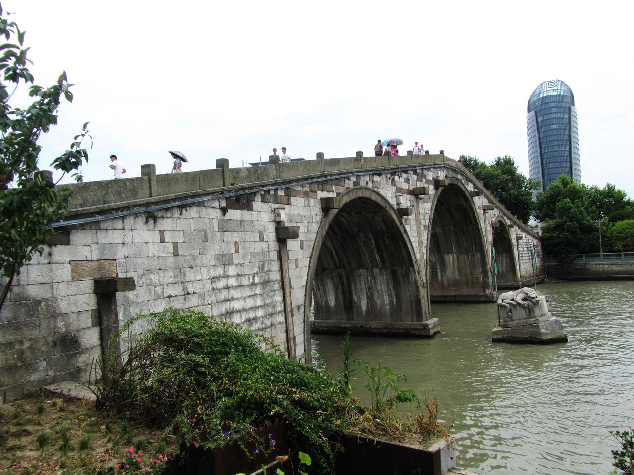 拱宸桥三孔石拱全景，桥下运河航道可见