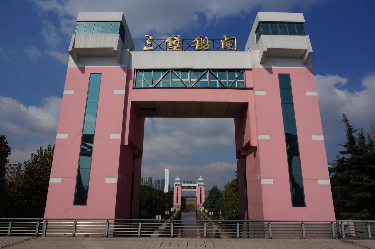 三堡船闸南侧，两道平行的钢闸门和横跨闸室的控制桥