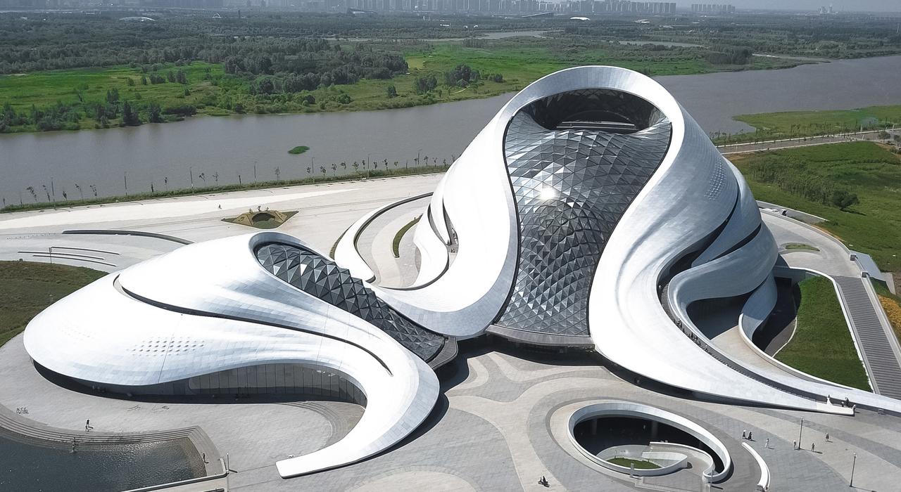 哈尔滨大剧院全景，白色曲线建筑从湿地中升起