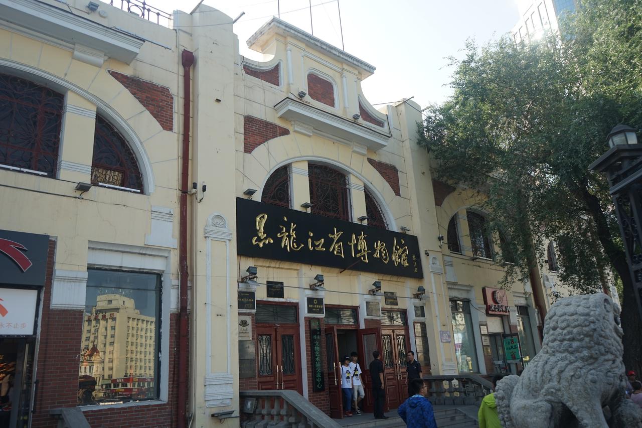 黑龙江省博物馆正面外观，可见米黄色墙面和暗红色穹顶