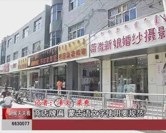 There are storefronts with signs displaying bilingual (Chinese and Mongolian) te