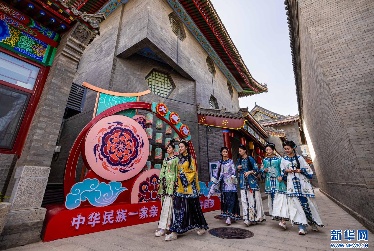Six women dressed in traditional Chinese clothing walk together through a histor