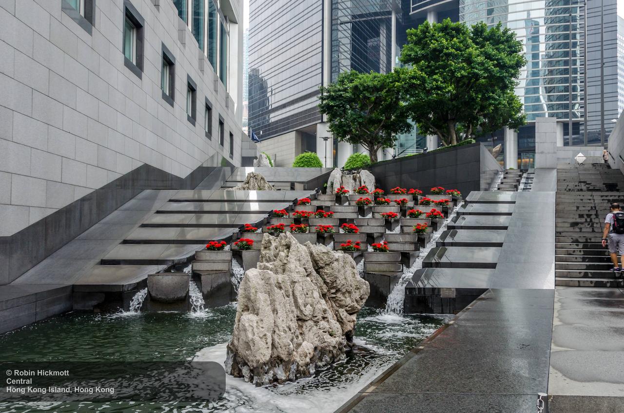 中银大厦基座的水景花园，三角形的水池呼应建筑几何，叠水瀑布和静水池利用坡地地形创造步行友好空间。