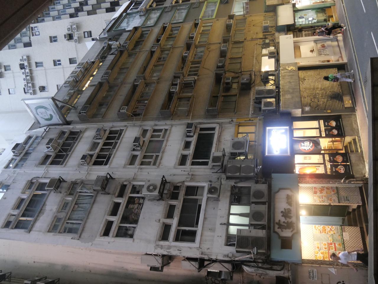 文咸西街两侧的药材铺和参茸店，传统书法招牌和骑楼柱廊构成街区最醒目的视觉特征。