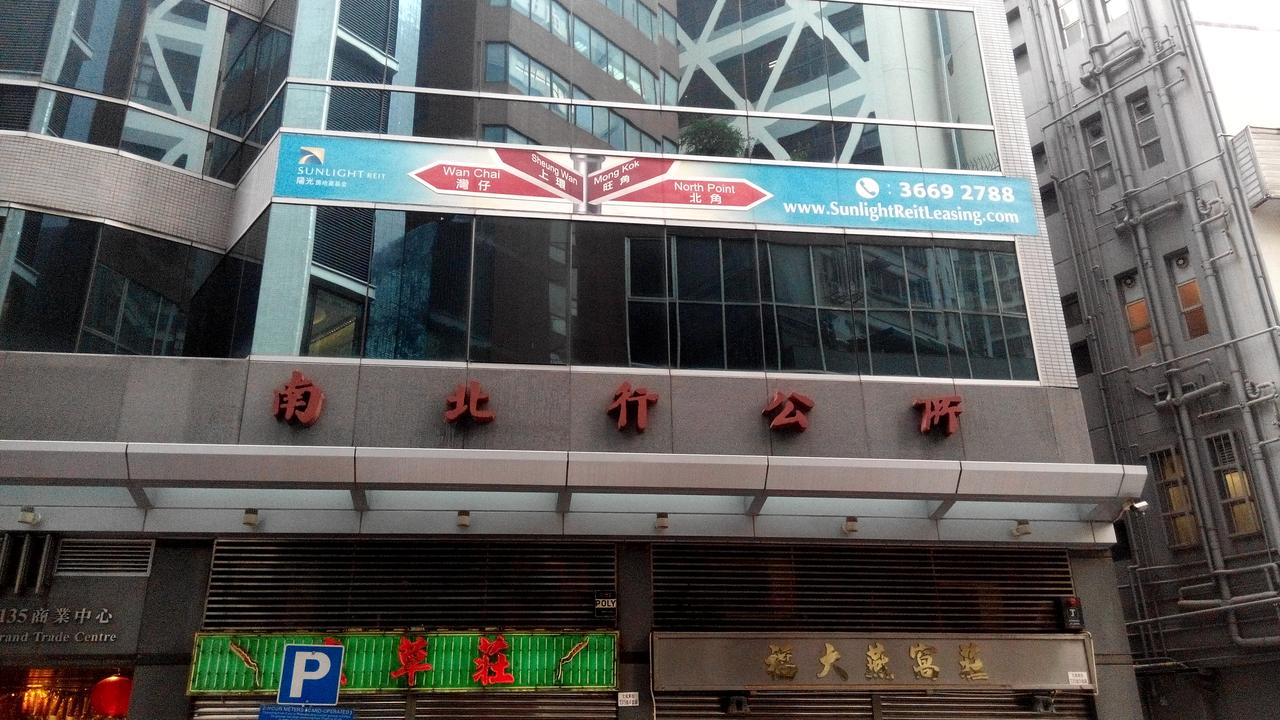南北行商业中心的现代化外观，现为南北行商会会址所在的大厦。底层可见传统药材铺，延续着街道的商业基因。
