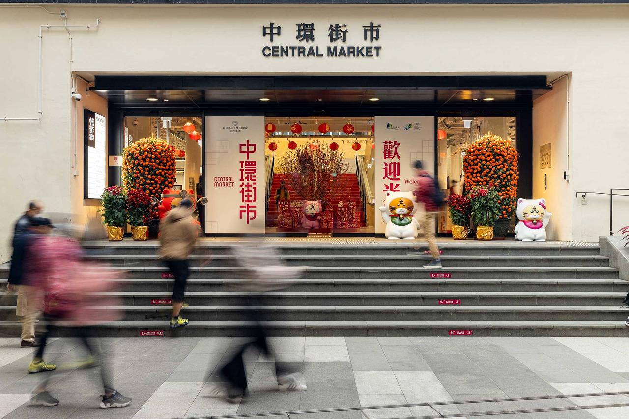 中环街市中庭,钢筋混凝土梁柱结构清晰可见,上方行人天桥连接扶梯系统