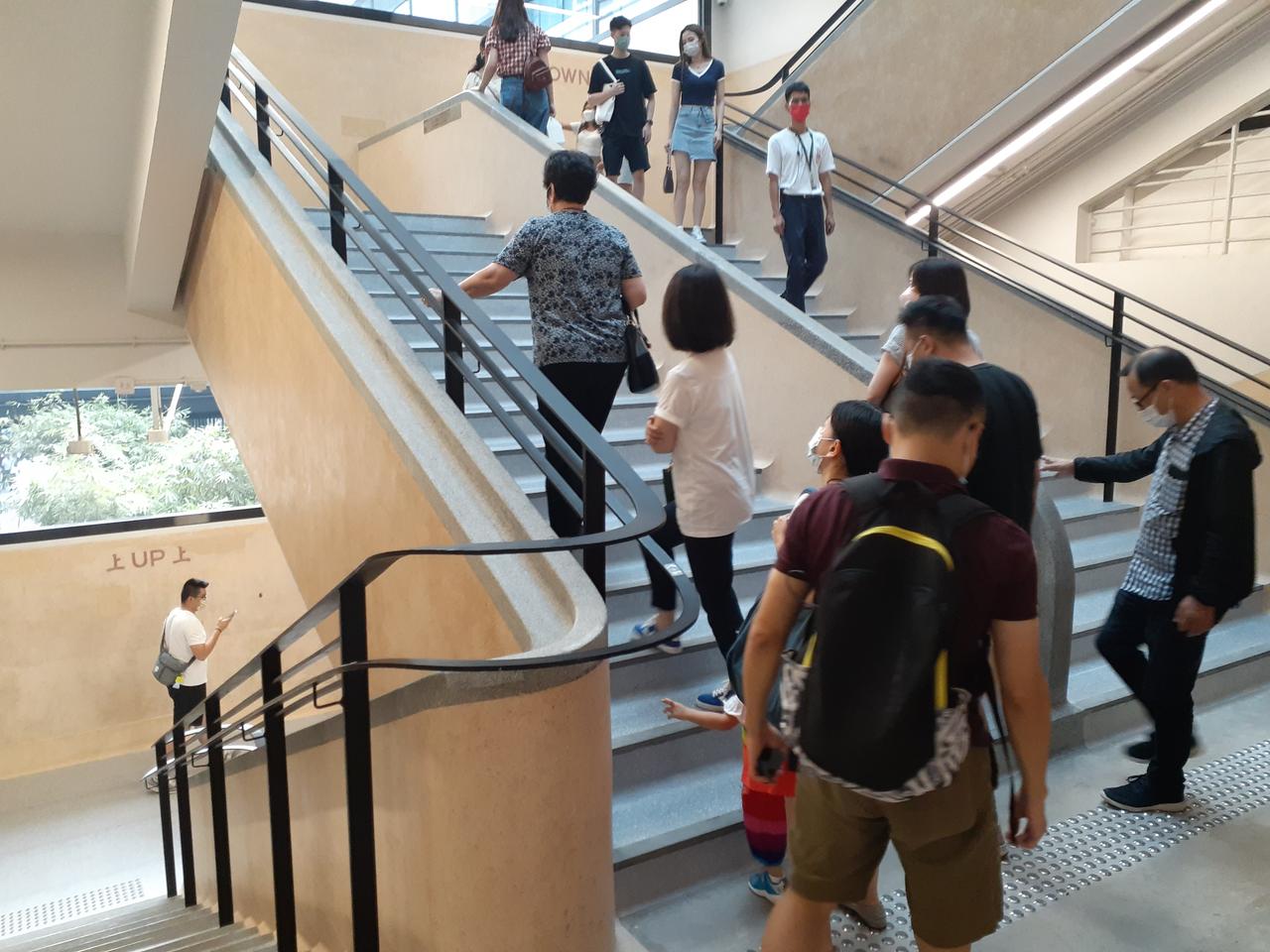 中环街市水磨石主楼梯,地面保留斑驳磨损痕迹,墙面可见"上""落"指示字样