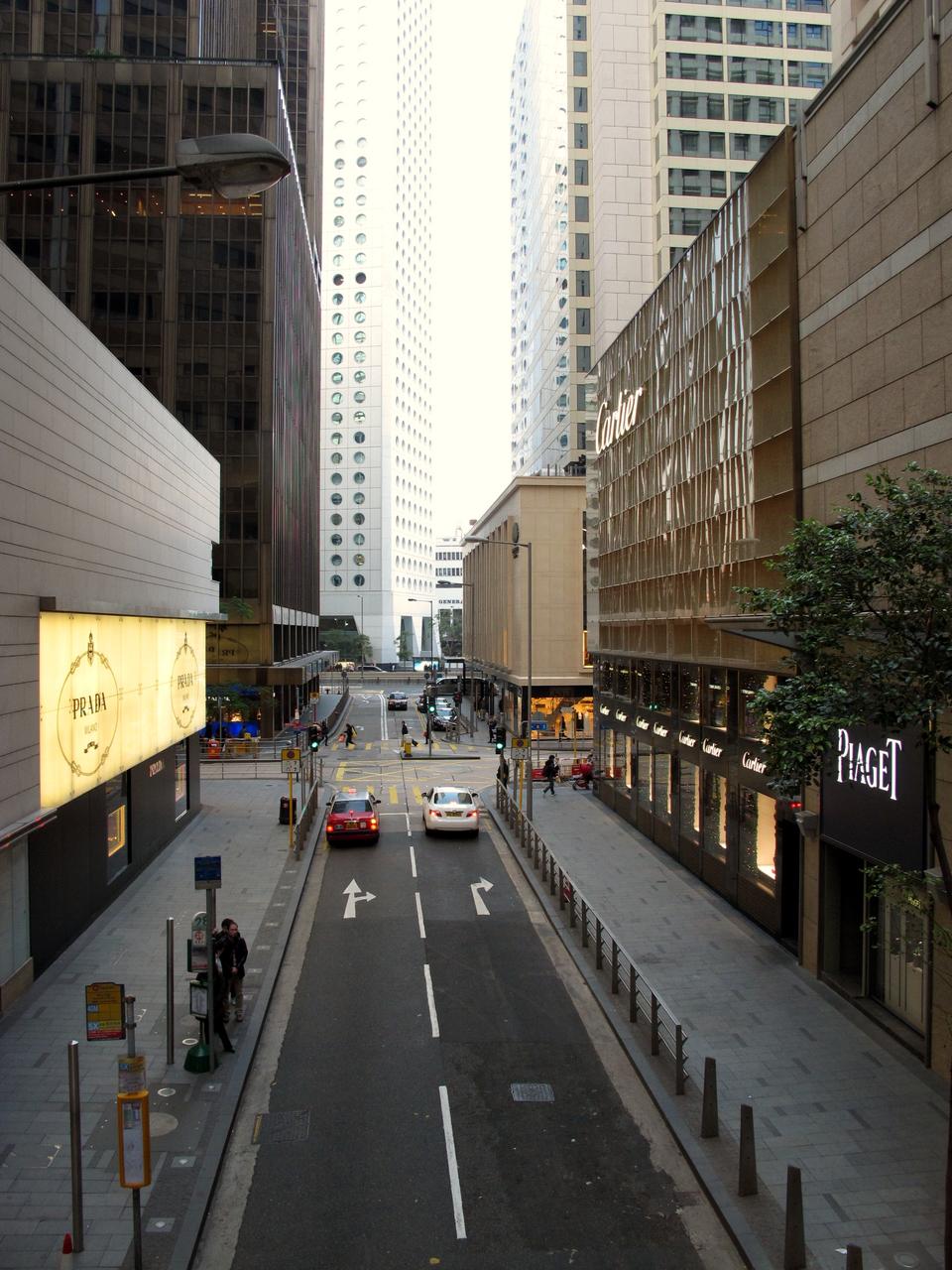 雪厂街由南向北的街景，单程下坡车道两侧是奢侈品商店和商业大厦