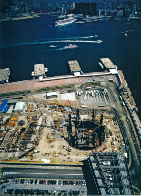 IFC 二期基坑施工时的圆形围堰。内径 61.5 米的连续墙穿越回填砂层和风化花岗岩后到达基岩，开挖深度约 55 米，被称为"香港最大的洞"。