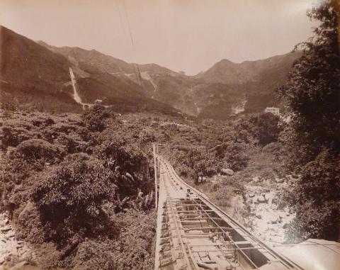 从花园道站台向上看，山顶缆车轨道以 25.7 度角插入中环摩天楼的缝隙中。