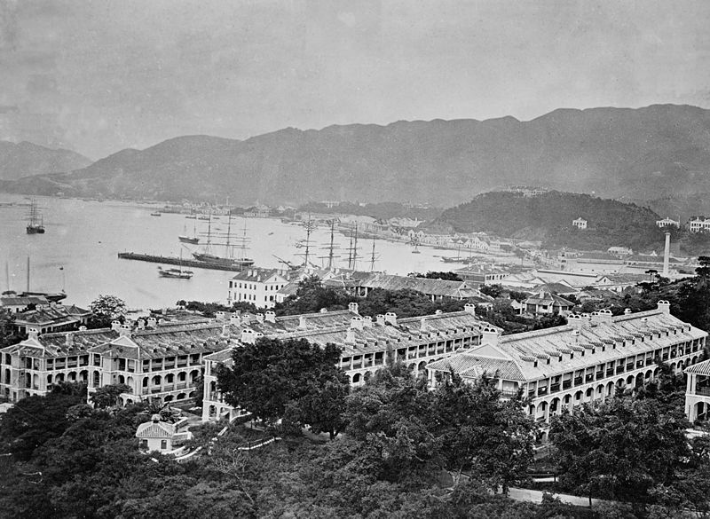 1870 年代维多利亚军营全景，可见多栋军人宿舍和远处的维多利亚港及海军船坞
