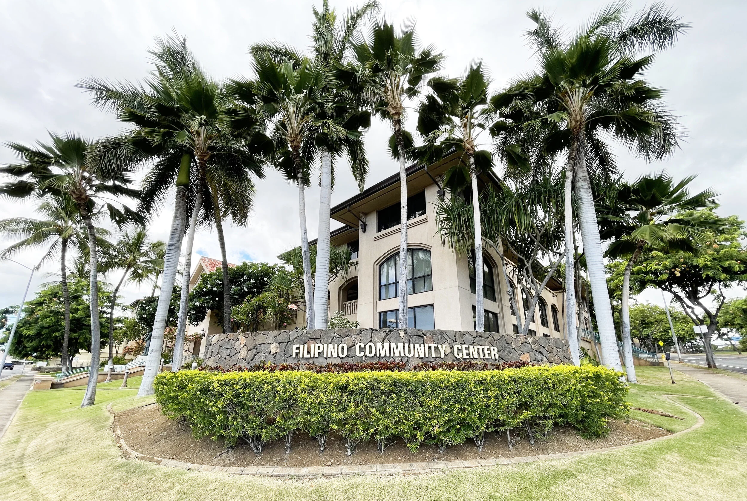 Filipino Community Center exterior in Waipahu with palm trees and the building name visible